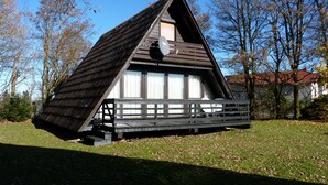 A wooden cabin with a sloped roof, a balcony, and a window with curtains. - Vacation Home at Weidenstraße 3 (Siegsdorf)