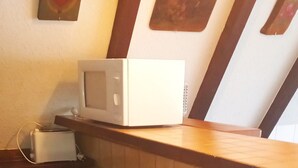 A kitchen area with a microwave, toaster, and a tiled countertop. - Vacation Home at Weidenstraße 3 (Siegsdorf)