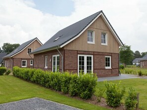 A modern two-story house with a sloped roof, large windows, and a well-maintained lawn. - Daelenbroeck 12 (Susteren)