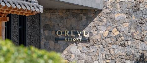 Un muro de piedra con el texto 'OREVE RESORT' que indica el nombre del establecimiento.