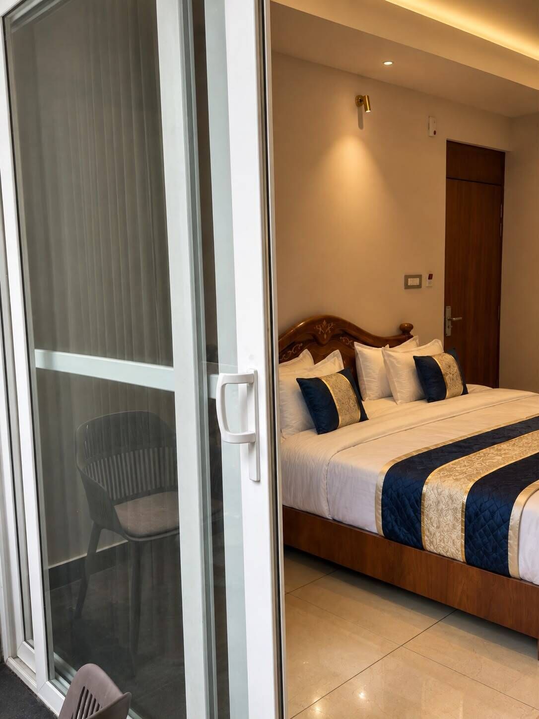 Ein Hotelzimmer mit einem Bett, einem Sessel und einer Schiebetür.