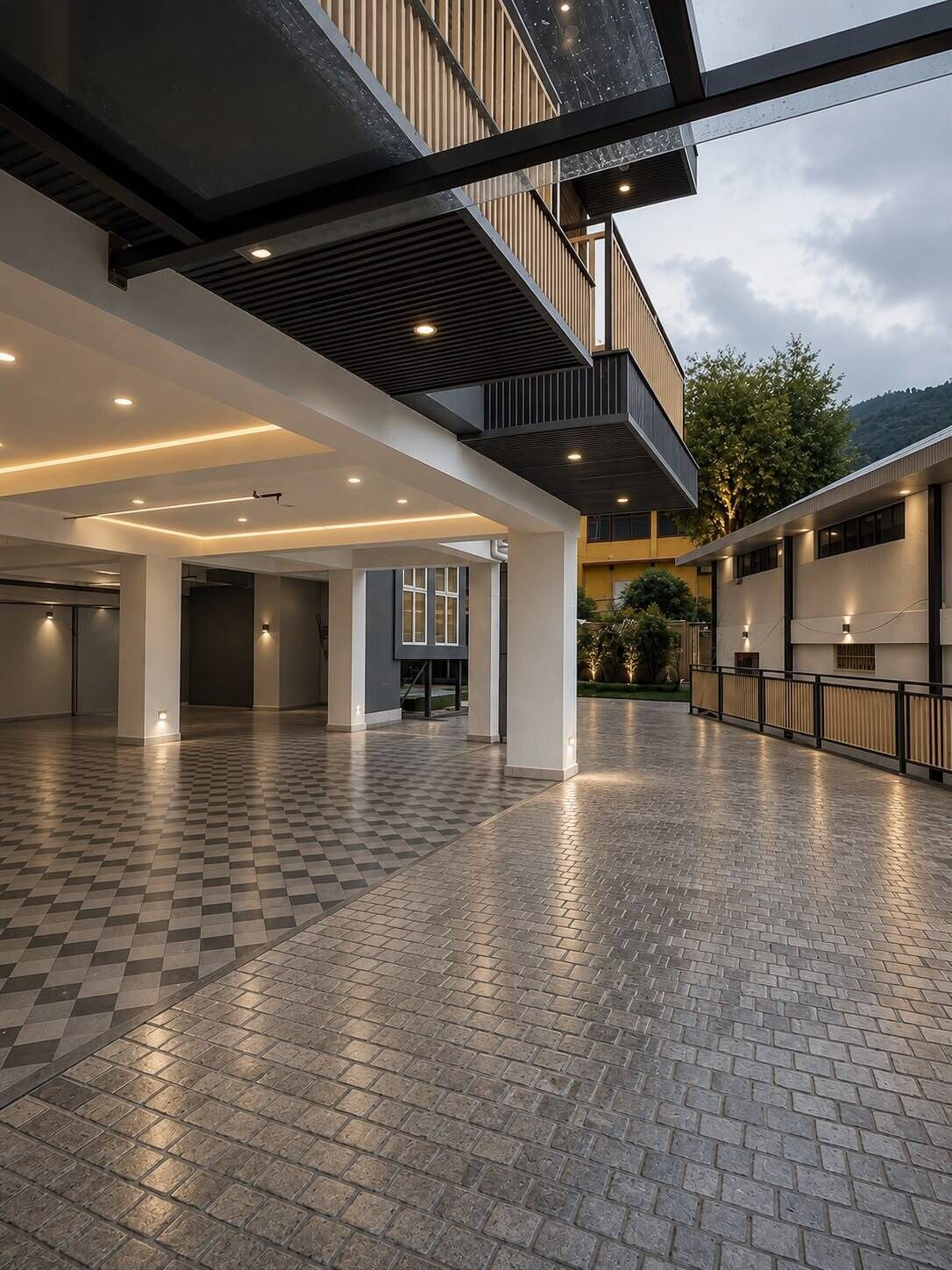 Un espacio interior amplio con piso a cuadros, un entrepiso y un balcón con vista a un jardín ajardinado.