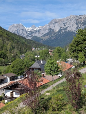 Ein Bergdorf mit traditionellen Häusern, einer Kirche und freiem Blick auf die Berge.