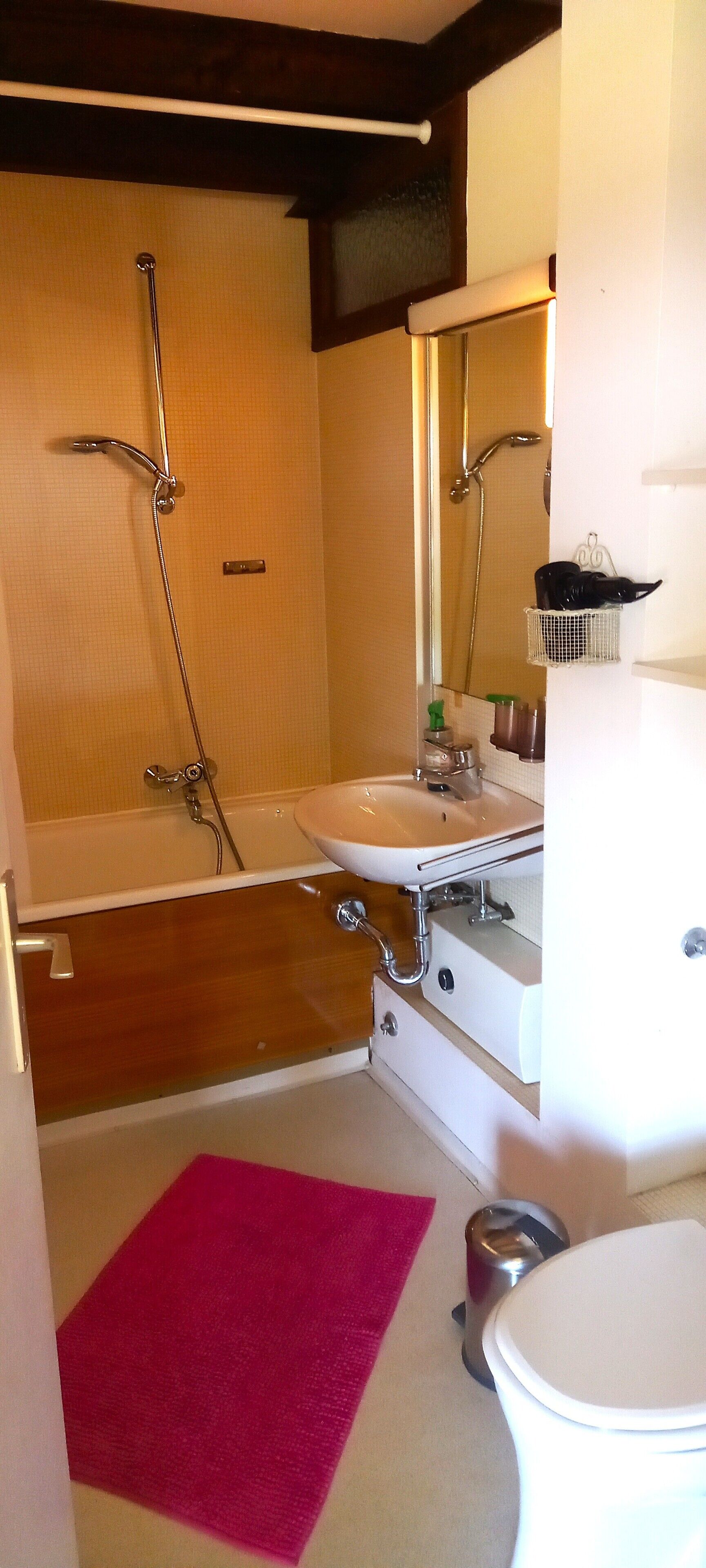 A bathroom with a bathtub, a sink, a toilet, a mirror, and a shower.