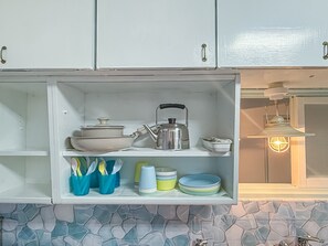 A kitchen with white cabinets, a stove, and a hanging light fixture. - A guesthouse that opened on Kaigan-dori in Tanabe City, Wakayama Prefecture, limited to one group of five guests per day (田辺市)