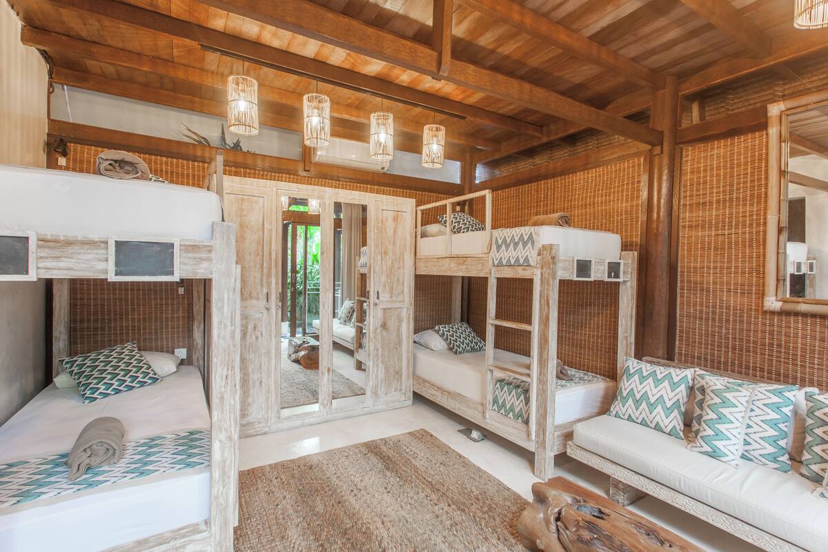 Una habitación rústica con literas, un sofá y techo de madera.
