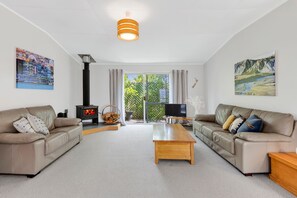 Ein Wohnzimmer mit zwei Sofas, einem Couchtisch, einem Kamin und Kunstwerken an den Wänden.
