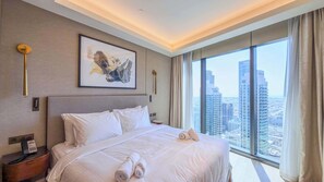 Ein Hotelzimmer mit einem großen Bett, Blick auf die Stadt, einem gerahmten Kunstwerk und modernem Design.