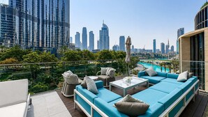 A rooftop terrace with a pool, seating area, and city skyline views. - Address Opera 1BR, Boulevard View-Hotel Style Stay (Dubai)
