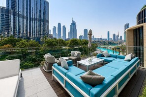 Eine Dachterrasse mit Pool, Sitzgelegenheiten und Blick auf die Stadtlandschaft.