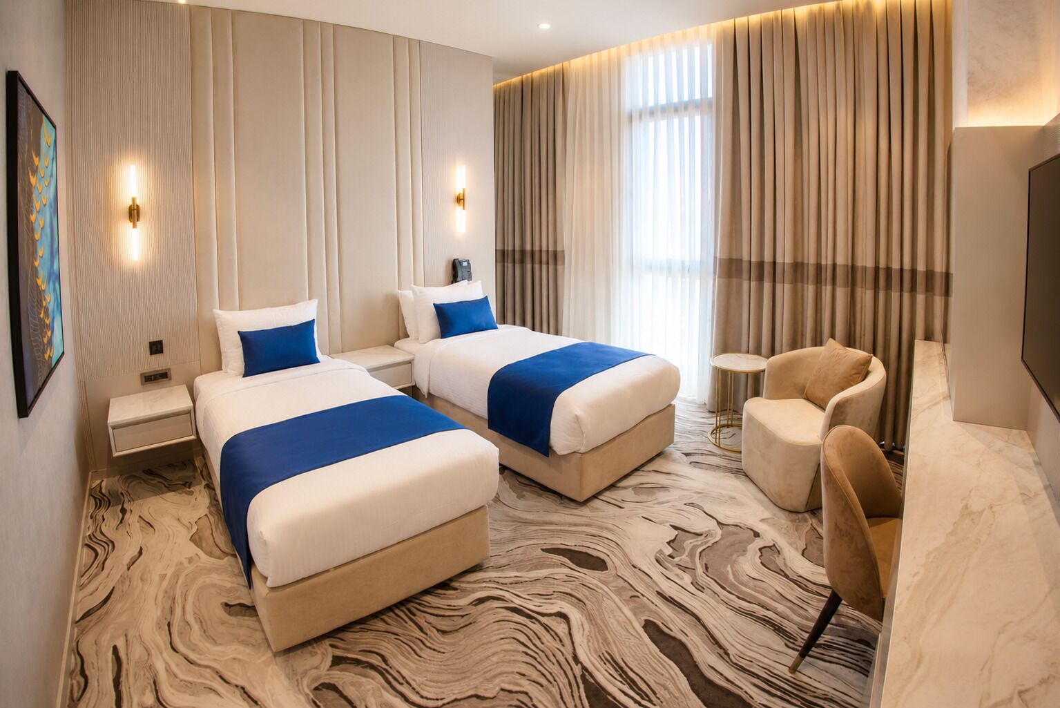 A hotel room with two beds, a seating area, and a television.