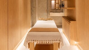 Un baño moderno con tocador de madera, cabina de ducha de vidrio y un espejo grande.