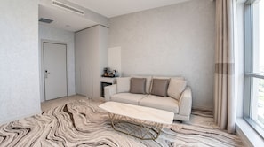 Una sala de estar moderna con un sofá, una mesa de centro y un tapete estampado.