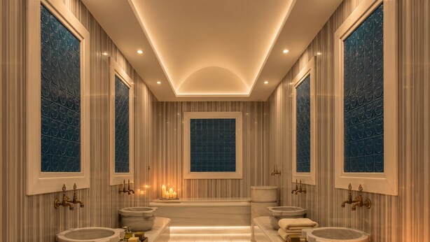Un baño lujoso con una bañera central, dos lavamanos y un espejo grande.