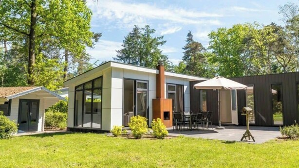 A modern house with a patio, a chimney, and a small garden. - Holiday Home in Brunssum With Terrace (Brunssum)
