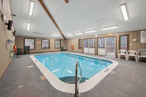 Una piscina con un puesto de socorrista, un jacuzzi y vistas al exterior.
