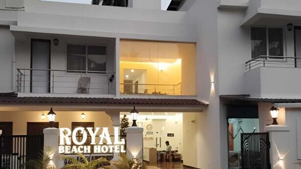 Kaksikerroksinen rakennus, jonka yläpuolella on kyltti, jossa lukee: ”ROYAL BEACH HOTEL”.