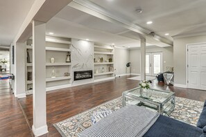 A spacious living room with a fireplace, built-in shelves, and a patterned rug.