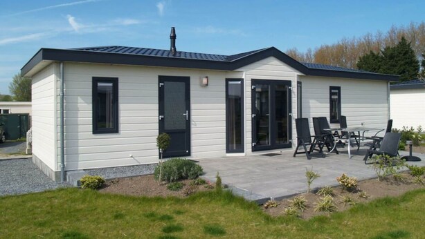 A single-story house with a patio, a chimney, and a small garden. - Holiday Home in Dordrecht With Terrace (Dordrecht)