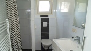 A small bathroom with a toilet, a sink, and a shower. - Holiday Home in Dordrecht With Terrace (Dordrecht)