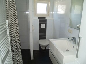 A small bathroom with a toilet, a sink, and a shower. - Holiday Home in Dordrecht With Terrace (Dordrecht)