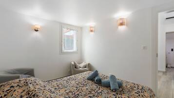 Une chambre à coucher avec un lit, une chaise et une fenêtre.