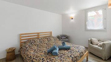 Una camera da letto con un letto di legno, un comodino, una sedia e una finestra con vista.