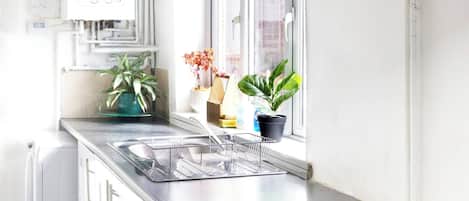 Una cocina moderna con horno empotrado, lavavajillas y ventana con vistas.