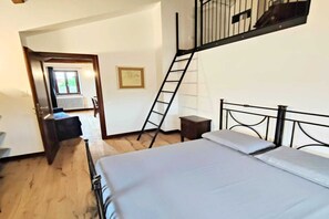A bedroom with a bed, a ladder, a small table, and a door leading to another room. - Apartment Camilla, Pesaro (Pesaro)