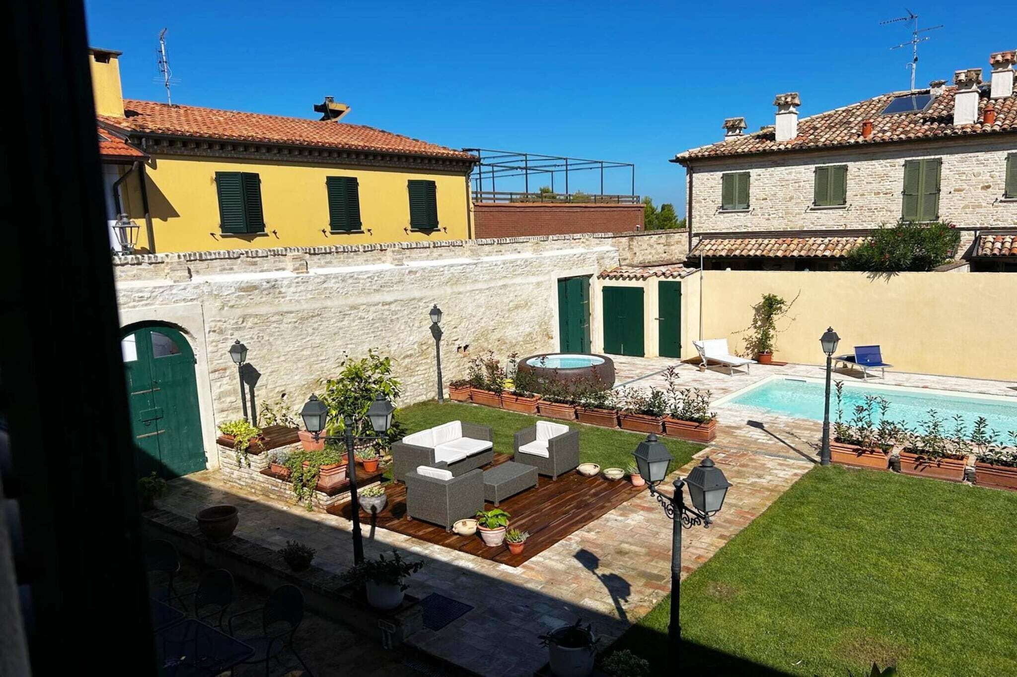 A courtyard with a pool, outdoor seating, and a view of surrounding buildings.