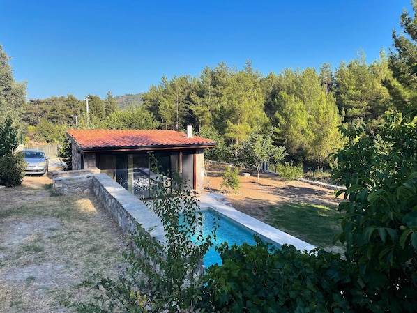 A house with a swimming pool, surrounded by trees and a car parked nearby. - Escape the noise, hear only nature’s voice (Karacahisar)