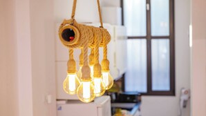 Una cocina con una lámpara colgante hecha de cuerda y bombillas.