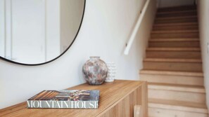 Ein hölzerner Konsolentisch mit einer Zeitschrift mit dem Titel 'MOUNTAIN HOUSE' und einer Vase darauf.