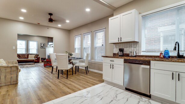 A modern kitchen with white cabinets, a marble countertop, and a built-in dishwasher. - Family-Friendly Detroit Duplex: Walk to Parks! (Detroit)