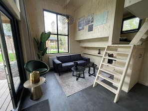 Een modern interieur met een bank, bijzettafeltje en een ladder.