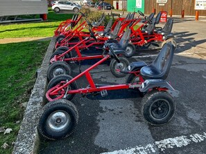 Een rij rode go-karts geparkeerd op een parkeerplaats.