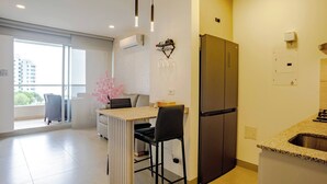 A modern kitchen with a built-in refrigerator, a bar counter, and a seating area with a chair. - Apartament with view at the sea close at the airport (Urb Don Jaca)