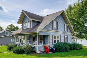 A two-story house with a porch, a covered front porch area, and a small front yard. - Historic Home on Beaver Dam Lake w/ Seasonal Dock (Cumberland)