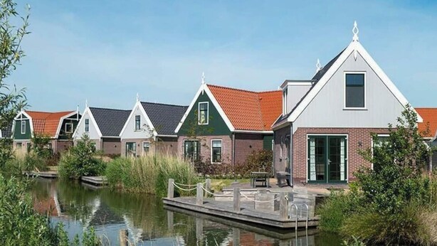 A row of houses with a canal in the foreground. - Holiday Home in Uitdam With Sauna (Uitdam)