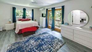 Un dormitorio con cama, cómoda, espejo y vistas al exterior.
