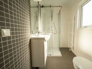 Ein Badezimmer mit Dusche, Waschbecken und Toilette.