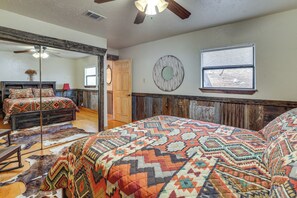 Een slaapkamer met een groot bed, een spiegel, een raam en een deur.