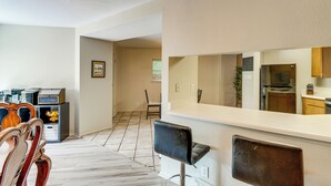 Uma cozinha moderna com bancada branca, geladeira e armários de madeira.