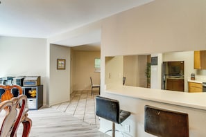 Eine moderne Küche mit weißer Arbeitsplatte, einem Kühlschrank und Holzschränken.