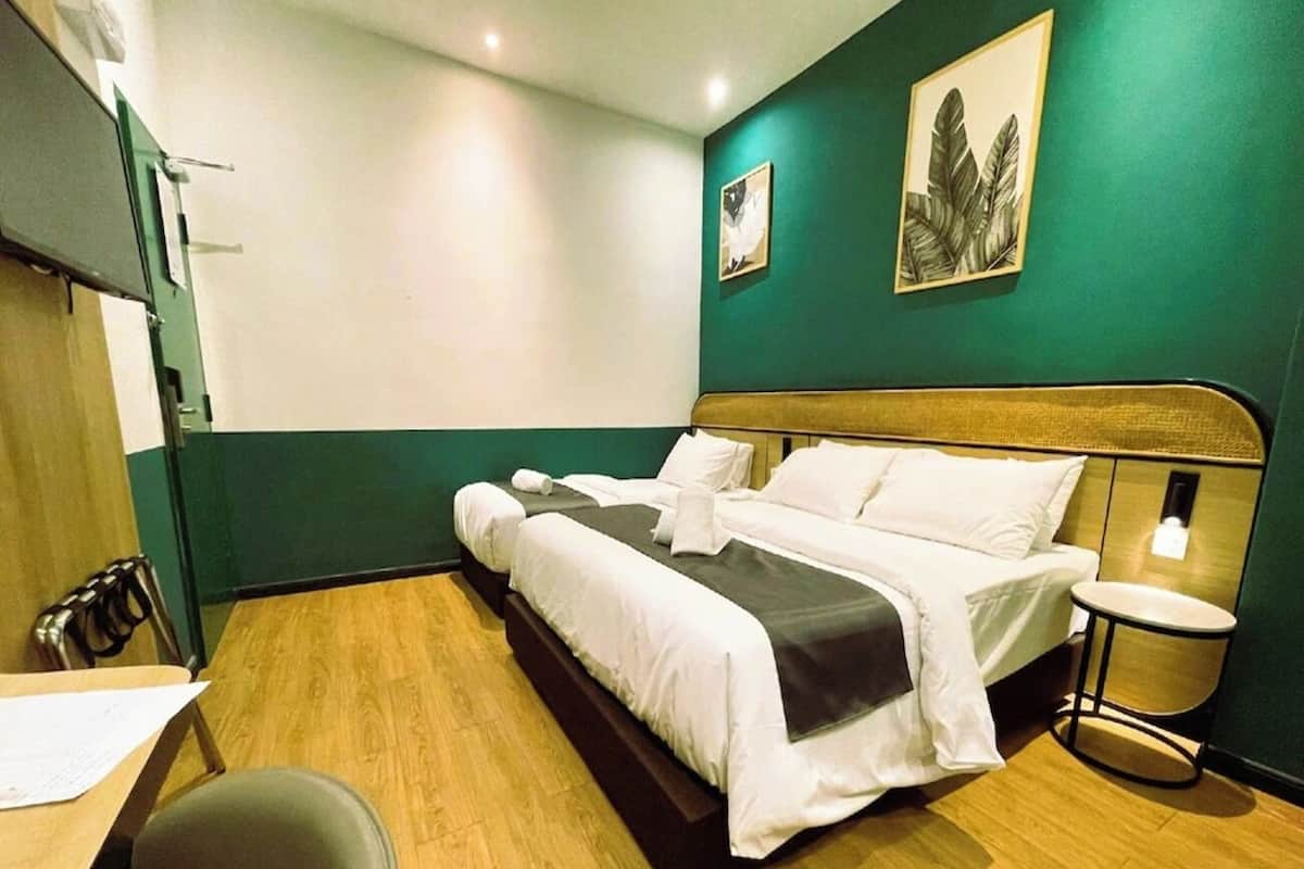 Ein Hotelzimmer mit einem Bett, einem Schreibtisch, einem Stuhl, einem kleinen Tisch und einer Wandleuchte.