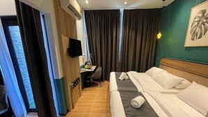 A hotel room with a bed, a desk, a chair, a TV, and a window with curtains. - Enclave Hotel Kuala Lumpur (Kuala Lumpur)
