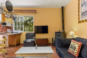 A living room with a sofa, a coffee table, a TV, and a fireplace.