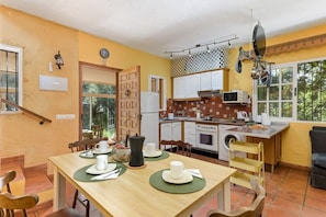A compact kitchen with white cabinets, a microwave, a stove, and a sink.
