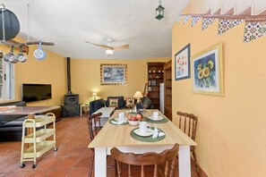 A dining area with a wooden table, chairs, and a TV.