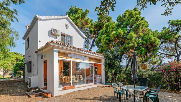 A two-story house with a patio area, outdoor furniture, and a view of the surrounding trees. - Estepona Mirador Country House (9 km from the beach) (Málaga)